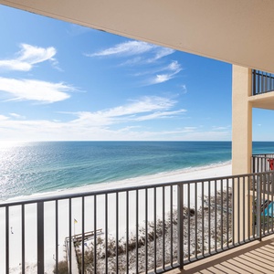 The balcony offers a breathtaking view of the beach and sparkling water, inviting relaxation and enjoyment of the scenery