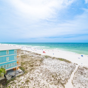 This bright view showcases the stunning beachfront with white sand and colorful umbrellas, perfect for a relaxing getaway