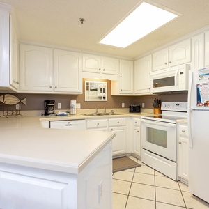 Bright white cabinetry and a spacious countertop create an inviting atmosphere in this inviting kitchen