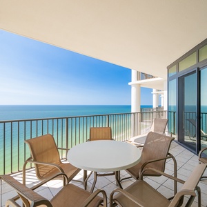 Enjoy stunning views from the spacious balcony, featuring a round table and comfortable seating for relaxation