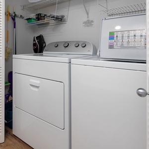 Laundry area featuring a washer and dryer with storage shelves above for added convenience during your stay