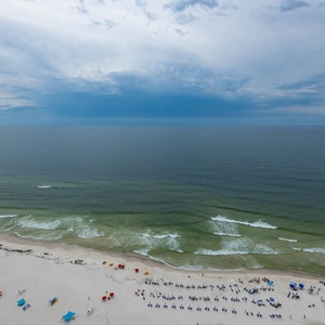 This stunning beachfront view showcases the serene waves and sandy shore from the twenty-fifth floor