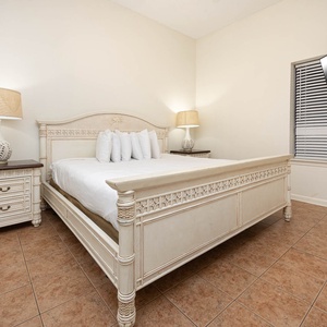 Relax in the inviting bedroom featuring a king bed, stylish decor, and a mounted TV for your entertainment