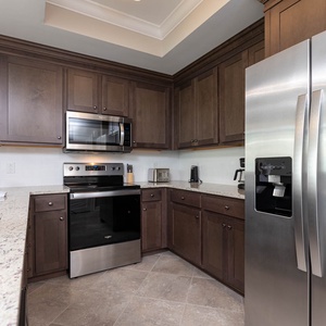 Prepare meals in this kitchen with elegant cabinetry, stainless appliances, and spacious countertops