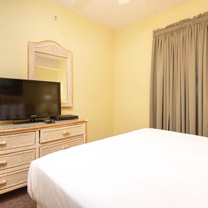 Unwind in this inviting guest bedroom featuring a TV, decorative dresser, and a cozy queen bed