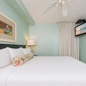 Fluffy pillows invite you to relax in the king suite for a calm movie night after a fun day at the beach