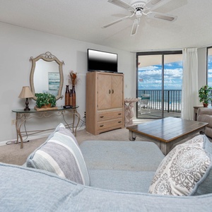 Relax in the spacious living area, featuring a comfortable sofa, stylish decor, and stunning beach views