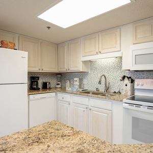 Bright kitchen features light cabinetry, granite countertops, and modern appliances, creating a welcoming space for meal prep