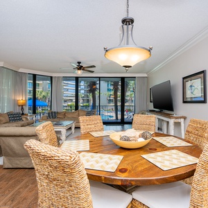 Relax on the plush sofa, soaking in the lively atmosphere from the large windows that frame the inviting pool views