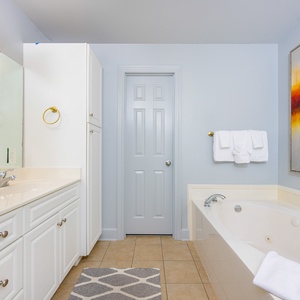 Refresh in the master bath after a day at the beach with a soothing jetted tub and relaxing walk-in shower