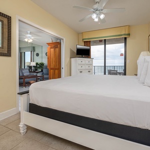 Relax in the comfortable master bedroom featuring a king bed and a view of the living area and beach balcony