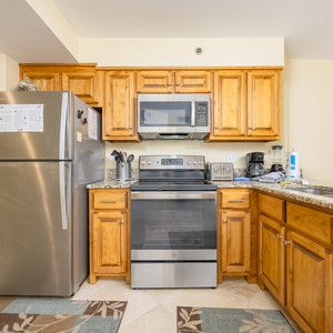 The kitchen features wooden cabinets, stainless appliances, and a granite countertop, perfect for meal prep and entertaining