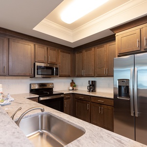 Prepare meals in this stylish kitchen with rich cabinetry and stainless appliances