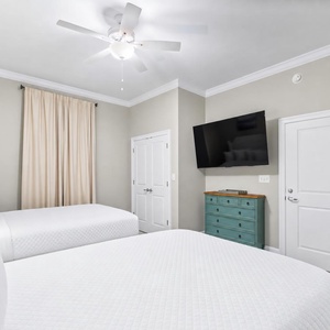 Unwind in this guest room featuring two queen beds, a TV, and a stylish dresser