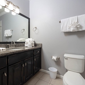 Spacious granite vanity with ample storage for your essentials and refreshing shower area in the guest bathroom