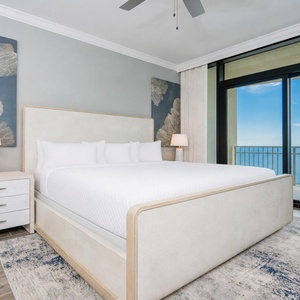 Relax in this serene master bedroom with a king bed, stylish decor, and the sights and sounds of the gulf coast