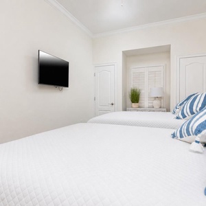 Stream your favorite shows in the guest suite with two cozy queens and relaxing decor