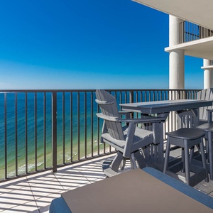 The balcony features comfortable seating with stunning beachfront views, perfect for relaxing and enjoying the scenery