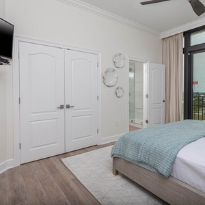 This bedroom features a cozy atmosphere with a king bed, TV, and stunning views from the large windows