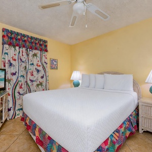 The guest suite's vibrant curtains bring a playful touch as you relax on the queen bed