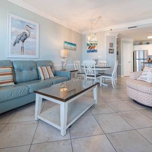 Relax in the airy living space, featuring a comfortable sofa, stylish decor, and a dining area for shared meals