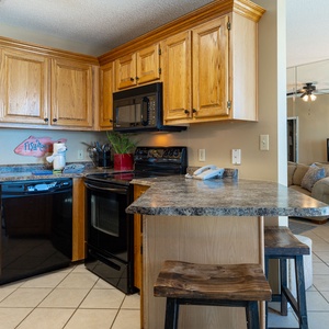Prepare meals in this inviting kitchen with wooden cabinets and a breakfast bar, perfect for family meals