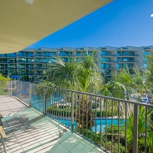 Bask in the sunshine while relaxing on the balcony, surrounded by palm trees and captivating pool views