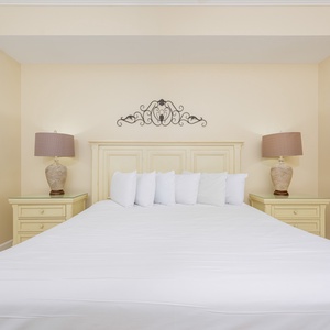 Master bedroom featuring a plush king bed, soft linens, and charming coastal decor