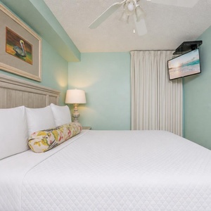 Fluffy pillows invite you to relax in the king suite for a calm movie night after a fun day at the beach