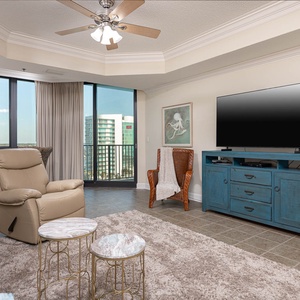 Relax in the inviting living area featuring a plush recliner, sofa with queen sleeper, stylish decor, and a large TV