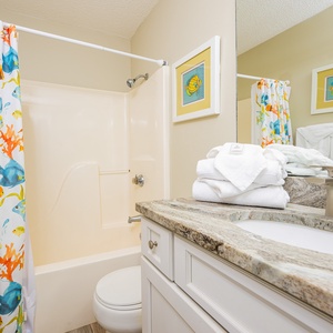 Refresh and rejuvenate in this guest bathroom, enjoying the cheerful decor and fluffy towels at your fingertips
