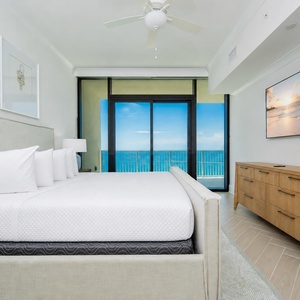 Experience restful nights in this inviting master bedroom with a king bed, large TV, and beachfront balcony access