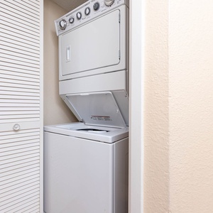 Washer and dryer set conveniently located in a compact laundry nook, ideal for refreshing beachwear during your stay