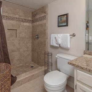 The master bath features a walk-in shower with elegant tile accents, a granite countertop, and plush towels for your comfort