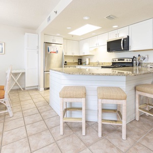 Kitchen area features granite countertops, a breakfast bar with seating, and modern appliances for convenient meal prep