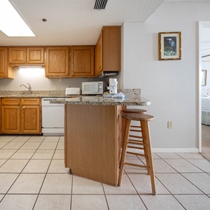 Prepare meals at the kitchen with wooden cabinetry, granite countertops, and a breakfast bar