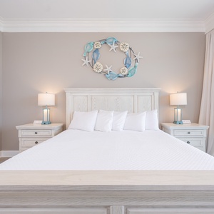 Relax in this serene master bedroom featuring a king bed, decorative accents, and beachfront balcony access