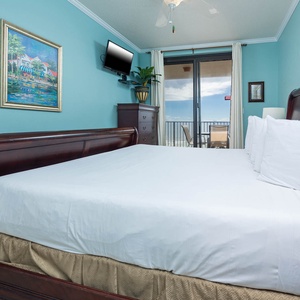 Inviting master bedroom featuring a plush king bed and beachfront balcony access with stunning views