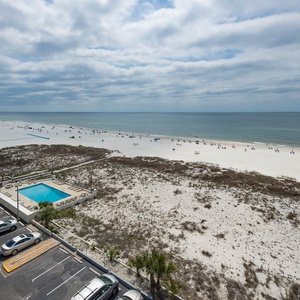 This inviting view showcases a serene beachfront with soft white sand, perfect for relaxation and fun in the sun
