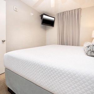 Discover your favorite beach retreat in this king suite with cozy bedding, wall-mounted TV, and adjoining bathroom