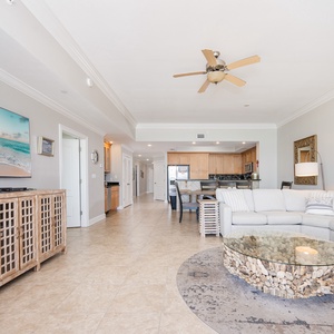 Relax in the inviting living area, featuring a spacious sectional sofa and coastal-inspired coffee table