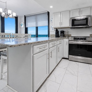 Upgraded kitchen features granite countertops, light cabinetry, and a coffee corner with a Keurig and coffee maker