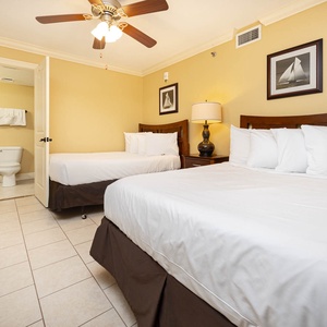 Brightly colored walls complement two double beds, a lamp, and artwork, creating a welcoming vibe in the guest bedroom