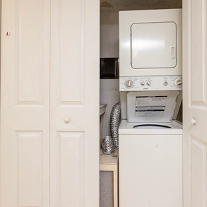 This laundry area features a stacked washer and dryer behind closed doors, maximizing space for your convenience