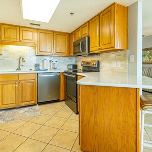 Warm wooden cabinets adorn the kitchen, featuring a coffee maker, sleek style, and ample storage