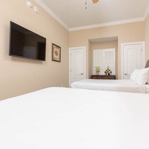 Unwind on plush queen bedding while enjoying your favorite shows in this guest suite after a day at the beach