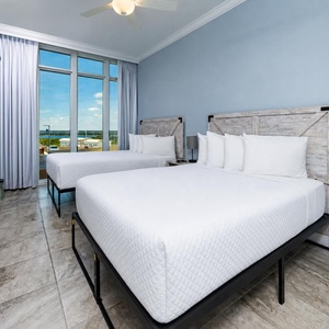 Enjoy an evening sunset in this queen suite with floor-to-ceiling windows showcasing coastal views