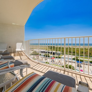 Relax on the colorful balcony chairs while enjoying the serene coastal view and bright blue sky