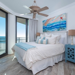 Relax in the serene guest suite with a plush king bed, coastal art, and expansive windows offering stunning views
