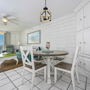 Living area features a round dining table, teal sofa with queen sleeper, and a vibrant coffee table, with expansive views